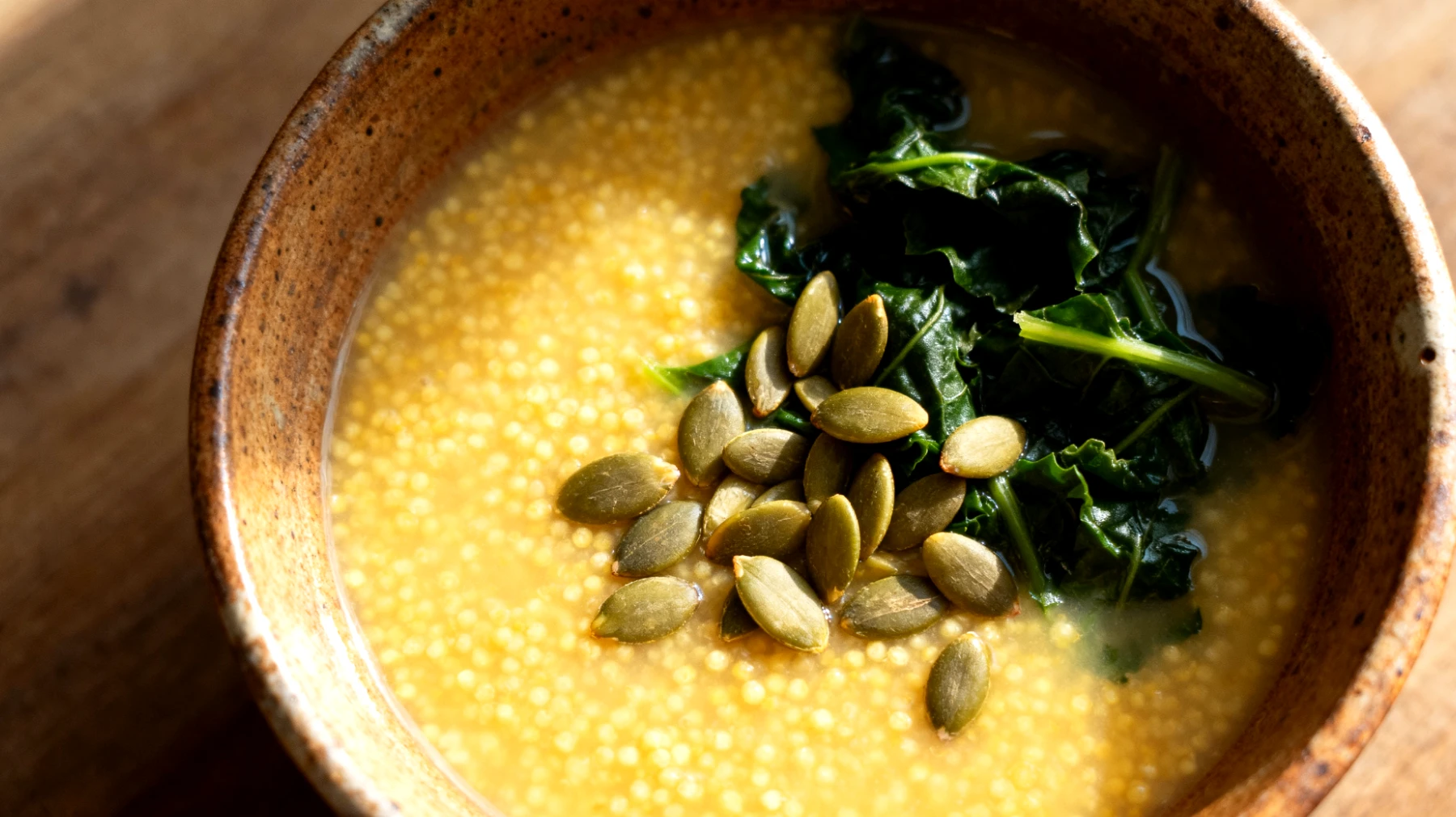 Zuppa di miglio con verdure amare e semi di zucca"